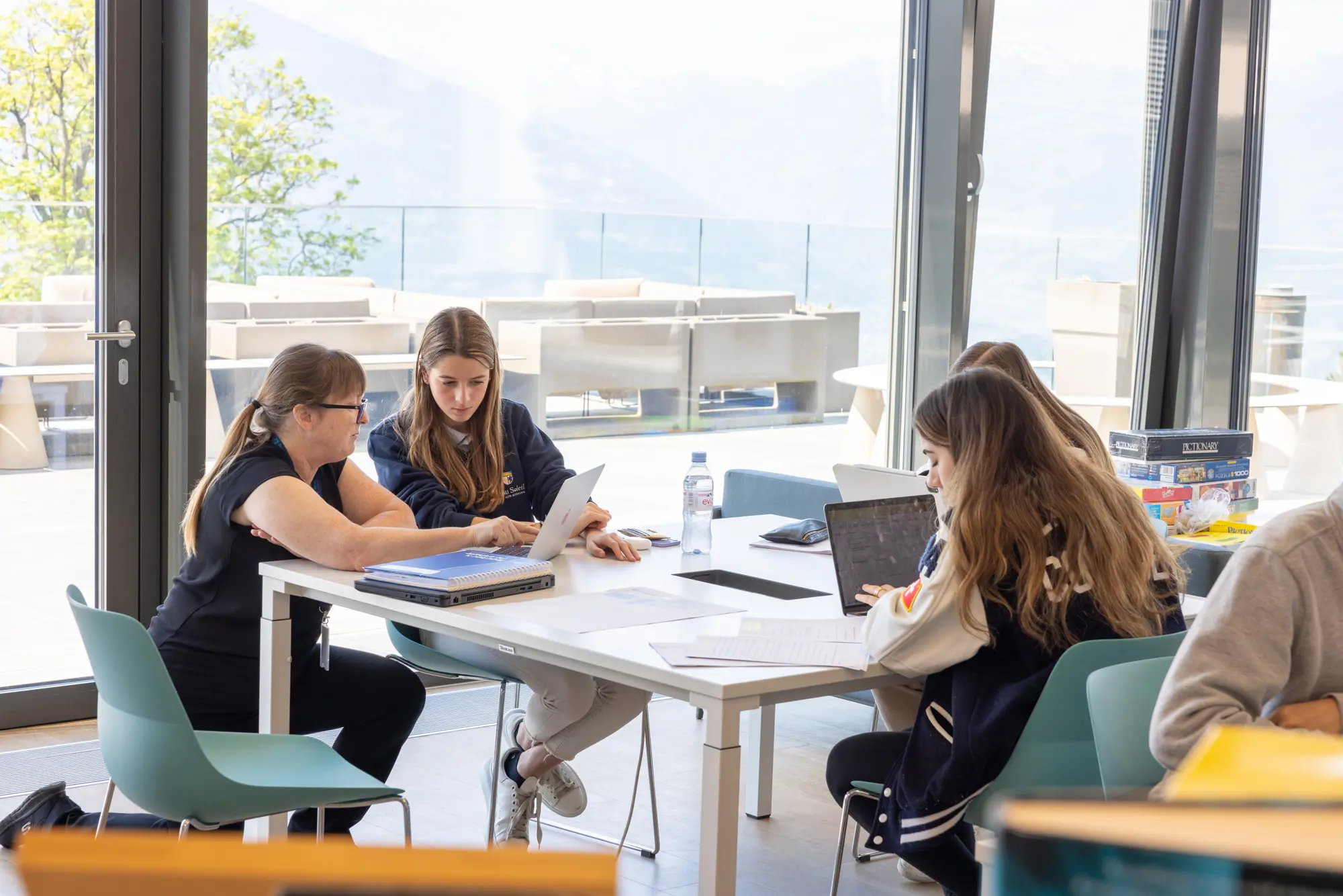 why are swiss schools so expensive - beau soleil article banner - pupils studying together with view of alps