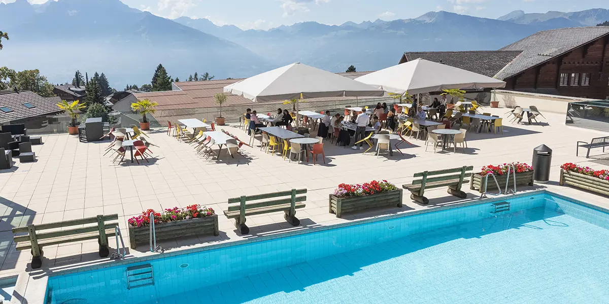 why are swiss schools so expensive - beau soleil article - world class facilities - campus and facilities - swimming pool overlooking alps